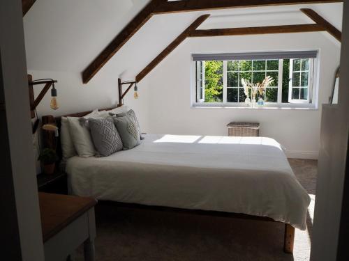 a bedroom with a large bed and a window at North Devon Holiday Cottage Dog Friendly with Local Pub in Swimbridge