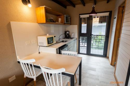 a small kitchen with a table and a microwave at Departamento Lake Soul Villa La Angostura in Villa La Angostura