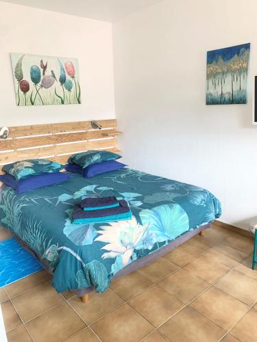 une chambre avec un lit avec une couette bleue dans l'établissement Les Chênes-lièges d'Ambeille, à Collioure