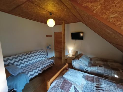 a attic room with two beds and a tv at Solorena in Junoszyno