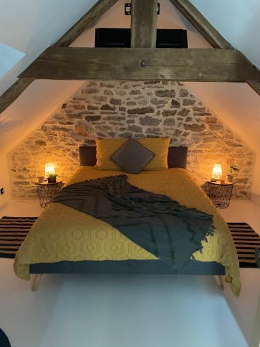 un lit dans une chambre avec un mur en pierre dans l'établissement Bella Vita Maison de charme au design soigné, à Lorient