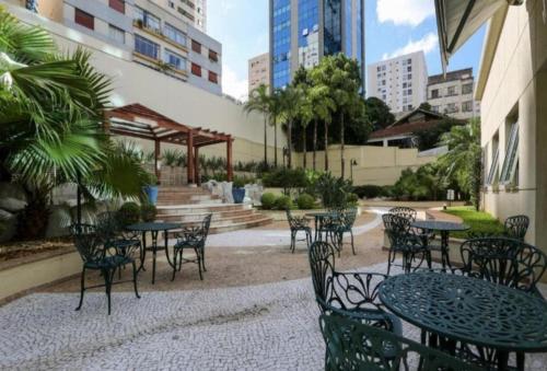 an outdoor patio with tables and chairs and buildings at Flat particular incrível dentro do hotel QS Oscar Freire, próximo ao Hospital das Clínicas in Sao Paulo