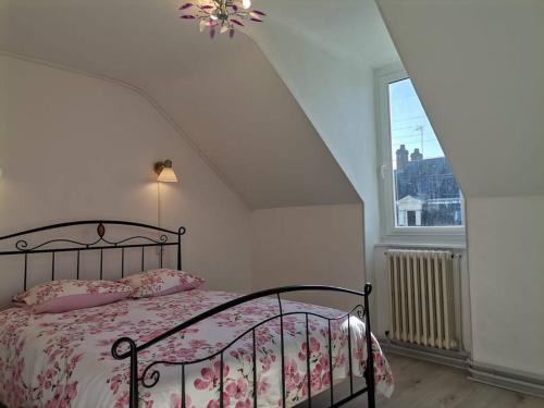 Schlafzimmer mit einem Bett mit rosa Bettwäsche und einem Fenster in der Unterkunft Grande maison de ville 120 m2 veranda et jardin. in Saint-Ouen