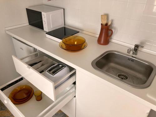 um balcão de cozinha com um lavatório e um micro-ondas em La Santa em Almagro