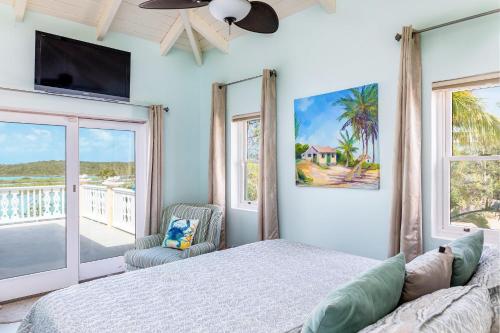 a bedroom with a bed and a flat screen tv at Chalk Sound Cottage with Pool Kayak in Providenciales