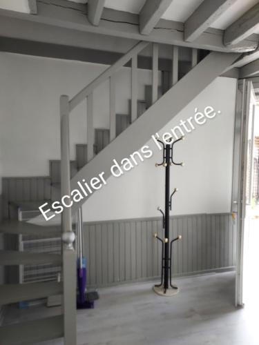 a cross in the middle of a room with a staircase at La Chaumière de Medee in Cuy