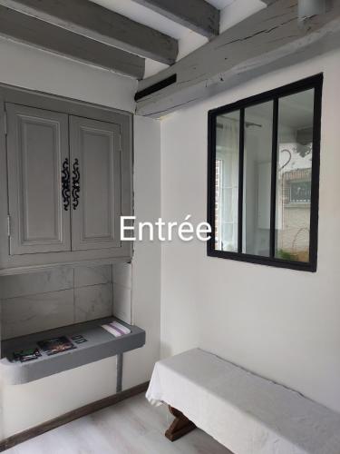 a room with a bench and a mirror on the wall at La Chaumière de Medee in Cuy