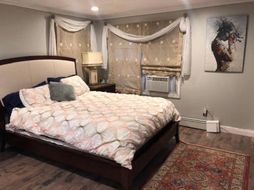 um quarto com uma cama grande e uma janela em 4 Bedroom House-- perfect for families, near the beach! em Glen Cove