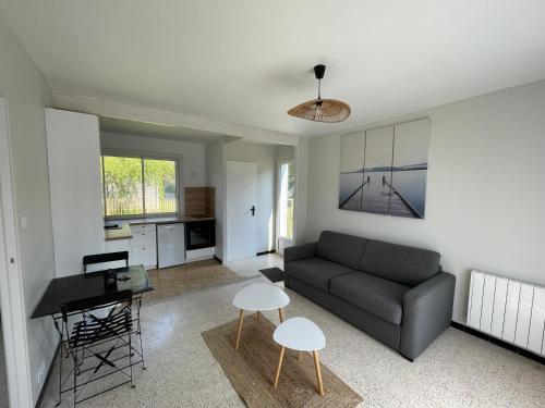 un salon avec un canapé et une table dans l'établissement Les Lucioles Fort-Mahon Plage, à Fort-Mahon-Plage