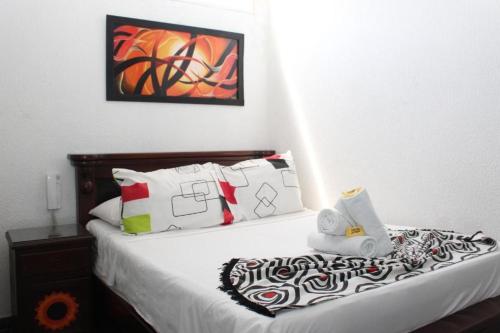a bedroom with a bed with white sheets and pillows at Hotel Villa del Rosario Nuevo in Melgar