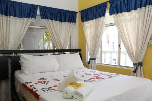 - une chambre avec un lit, des serviettes et une fenêtre dans l'établissement Hotel Villa del Rosario Nuevo, à Melgar