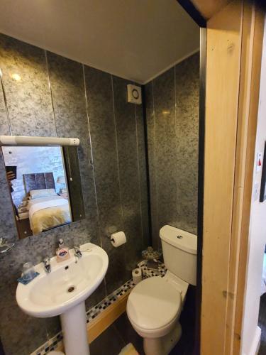 bagno con lavandino, servizi igienici e specchio di Windsor House Hotel a Blackpool