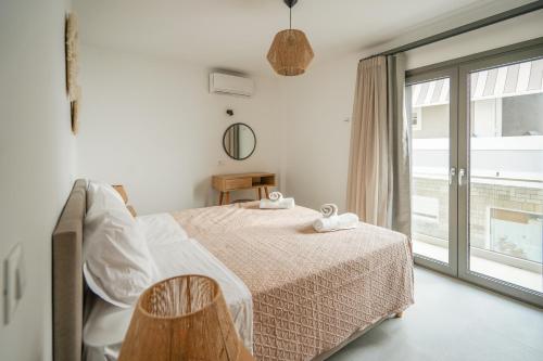 una camera bianca con un letto e una finestra di Sandy feet comfort suite a Kardámaina
