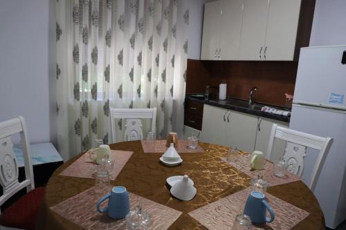 Il comprend une cuisine équipée d'une table, de chaises et d'un réfrigérateur. dans l'établissement Blei & Dei Apartment, à Berat