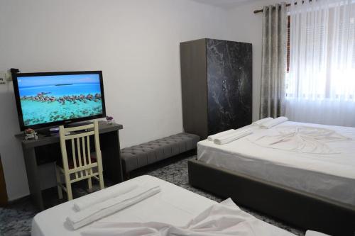 Cette chambre comprend 2 lits et une télévision à écran plat. dans l'établissement Blei & Dei Apartment, à Berat