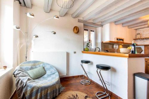 - une cuisine avec une table et deux tabourets dans une pièce dans l'établissement La ferme du château, à Venon