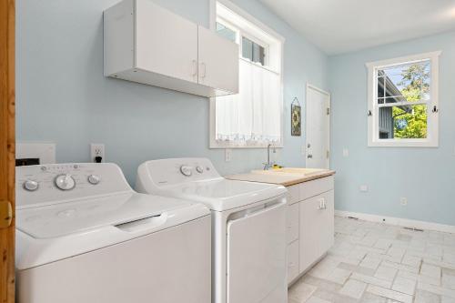 een witte wasruimte met een wasmachine en droger bij Seashell Cottage in Blaine