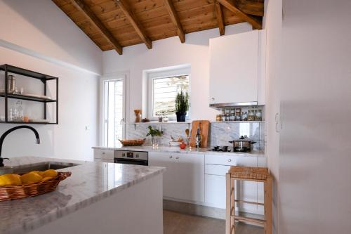 a kitchen with white cabinets and a counter top at Villa Sofia Old Town in Kavala