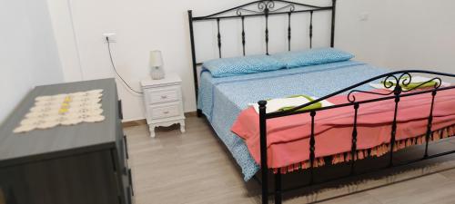 um quarto com uma cama preta e uma mesa de cabeceira em Piccola LoLu em Ortona