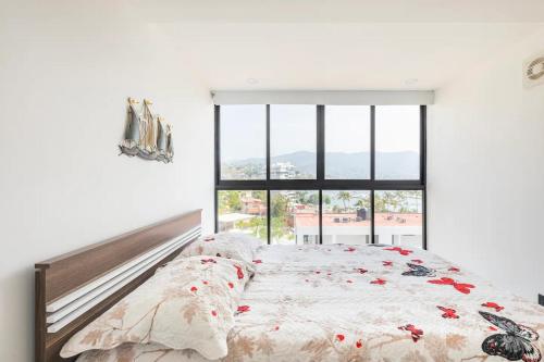 a bedroom with a bed and a large window at Departamento en Condominio Astoria in Acapulco