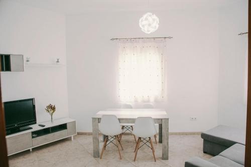 una sala de estar blanca con mesa y sillas en Casa a 3 minutos del Casco y con facil aparcamiento- El rincón de Carmela en Talavera de la Reina