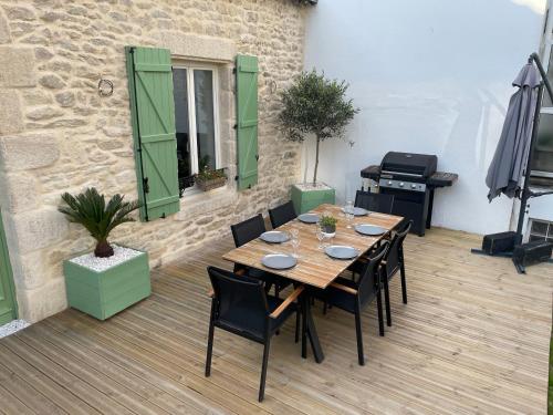 une table et des chaises en bois sur une terrasse dans l'établissement Bella Vita Maison de charme au design soigné, à Lorient