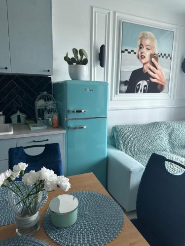 a kitchen with a table and a picture of a woman at Apartament na Wzgórzu Miętowy in Łańcut