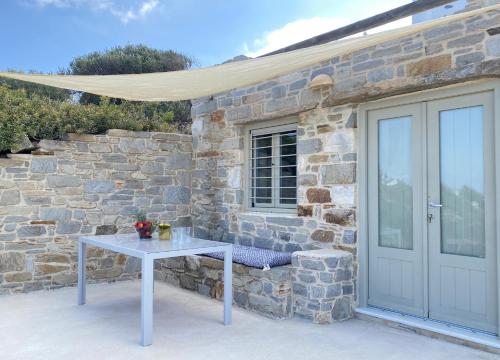 a white table in front of a stone building at Aegean Breeze House in Kampos Paros