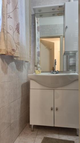 uma casa de banho com um lavatório branco e um espelho. em Romantic2 em Szeged