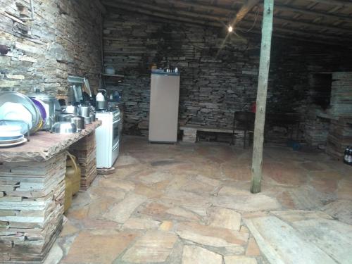 uma cozinha com um fogão e uma parede de pedra em Camping do Cid (no centro) em São Tomé das Letras