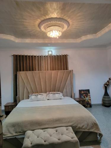 a bedroom with a large bed with a large headboard at S&M HOUSE in Lekki
