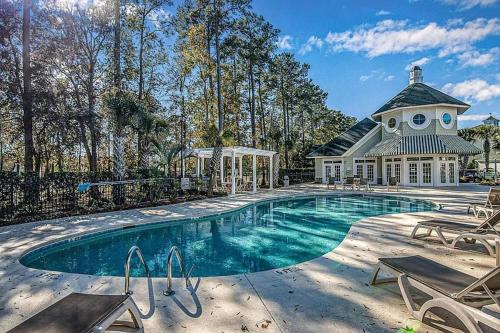 a large swimming pool with a house in the background at Golfer's Delight at World Tour Golf in Myrtle Beach
