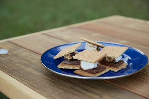 a blue plate of sandwiches on a wooden table at Tentrr State Park Site - Nebraska Louisville SRA - Riverview D - Single Camp 