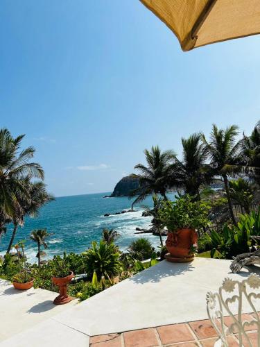 a view of the ocean from a resort with palm trees at Villas Fasol Huatulco in Santa Cruz Huatulco