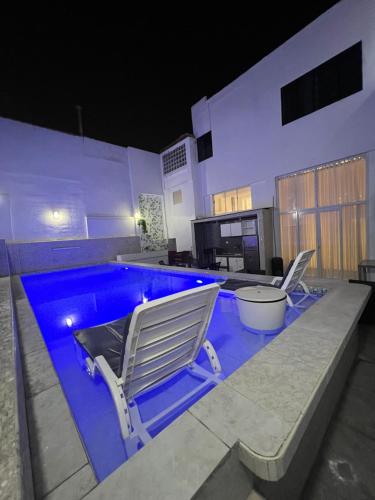 una piscina con 2 sillas de jardín junto a ella en Departamento La Punta B - Piscina - Zona parrilla en Lima