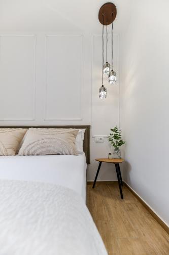 a bedroom with a white bed and a table at Apartment "Libra" Zadar in Zadar
