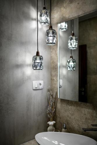 a bathroom with a sink and a mirror and lights at Apartment "Libra" Zadar in Zadar