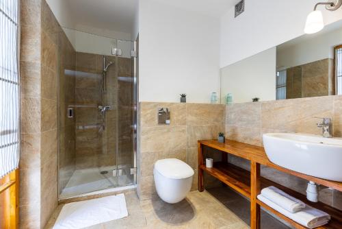 a bathroom with a sink and a shower and a toilet at Biały Dom W ROPKI in Ropki