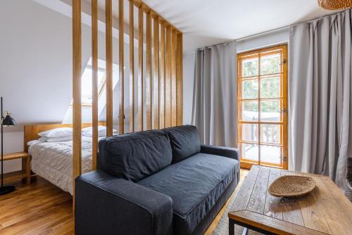 Biały Dom W ROPKI في Ropki: غرفة معيشة مع أريكة وسرير