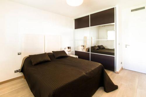 a bedroom with a large black bed in a room at Croisette View Lux Flat Cannes in Cannes