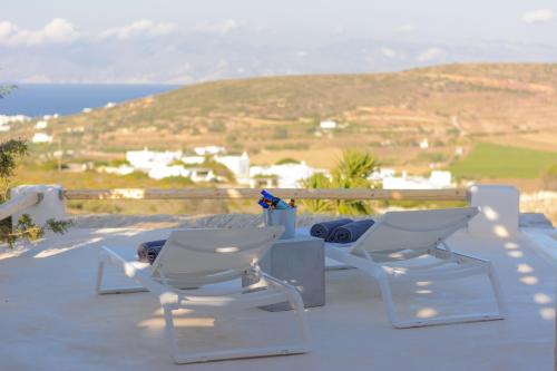 two chairs and a table on a balcony with a view at Aegean Breeze House in Kampos Paros