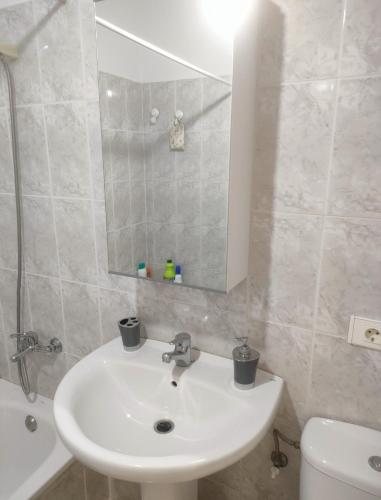 een badkamer met een wastafel, een toilet en een spiegel bij Casa Noas in Playa Blanca