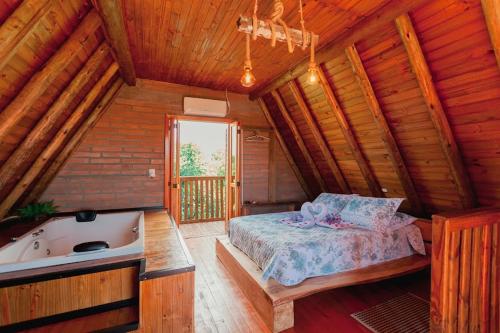 una camera con letto e vasca in una cabina di HOSPEDAGEM LA NO SITIO a Praia Grande