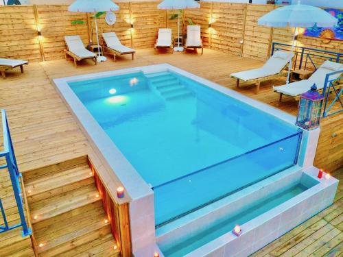 una grande piscina in una stanza con sedie e ombrelloni di Villa Trousas Kassiopi with private pool a Kassiopi