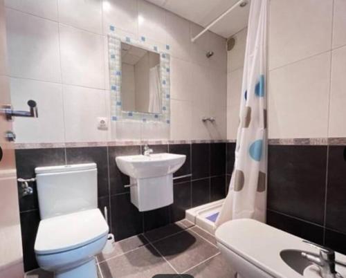 La salle de bains est pourvue de toilettes, d'un lavabo et d'une baignoire. dans l'établissement Apartamento cerca del mar en Castellon, à Grao de Castellón