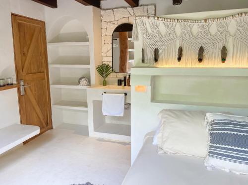 a room with a bed and a room with a door at Amansala Resort in Tulum
