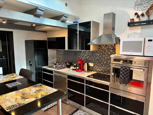 a kitchen with stainless steel appliances and a stove at Appart en duplex climatisé cœur de ville in Périgueux