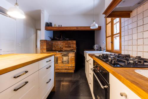 a kitchen with white cabinets and a stove top oven at Biały Dom W ROPKI in Ropki