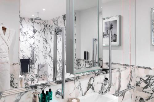 ein Bad mit einem Waschbecken und einem Spiegel in der Unterkunft The Wellesley, a Luxury Collection Hotel, Knightsbridge, London in London