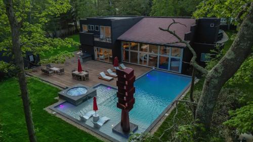 a house with a swimming pool in the backyard at Enjoy the Spa all year round in this EHV Estate in East Hampton